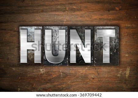 The word "Hunt" written in vintage metal letterpress type on an aged wooden background.