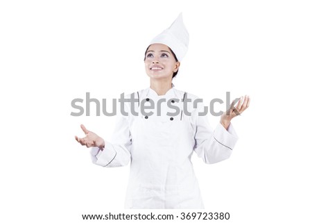 Picture of indian woman chef wearing uniform with juggling pose in the studio, isolated on white background