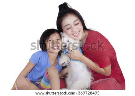 Picture of beautiful little girl and her mother hugging a maltese dog in the studio, isolated on white background