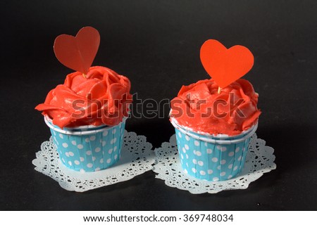 two cupcakes with red butter cream in blue polkadot cup. Romantic conceptual