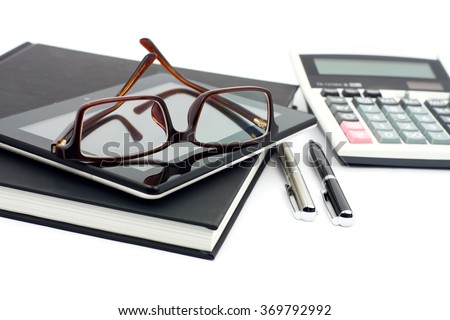 Eyeglasses, tablet, notebook, pens and accounting calculator in Business concept on isolate white background