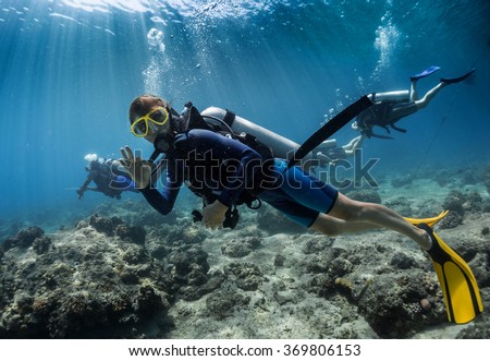 Lady scuba diver showing ok signal underwater