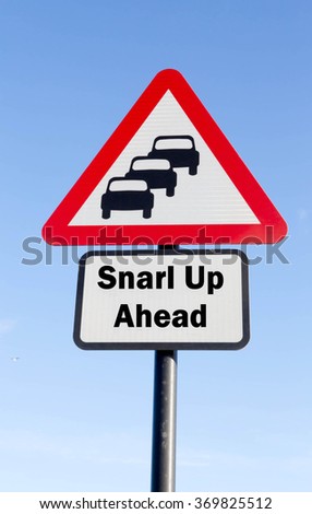 Red and white triangular road sign with a Snarl Up Ahead concept against a partly cloudy sky background