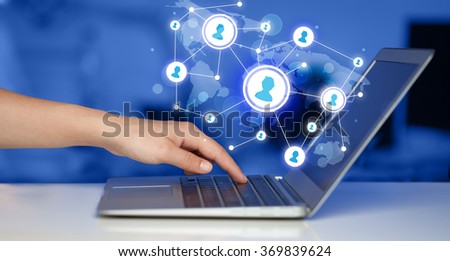 Close up of hand with laptop and social media network icons