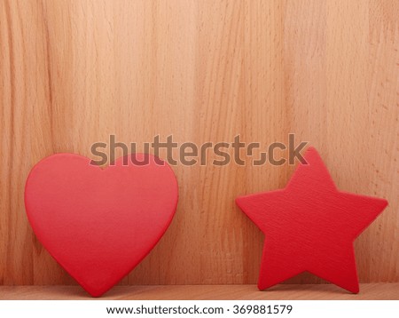 Red heart and asterisk on a wooden background.