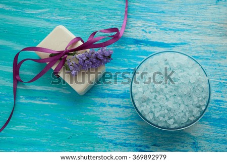 natural organic soap, and sea salt with flowers on a blue wooden table