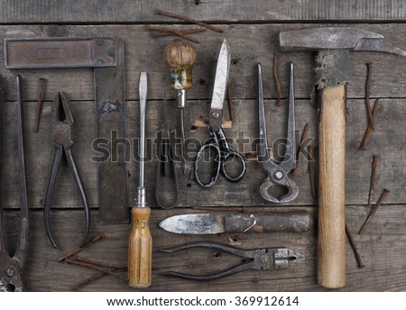 Old and rusty used tools on a rustic wooden table