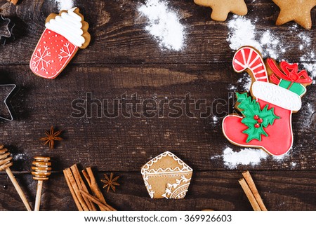 Christmas cookies, cinnamon, meal and two spoons for honey on dark brown wooden table, point of view, copy space.