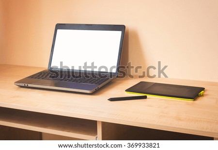 laptop and graphics tablet on wooden table