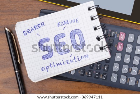 inscription SEO in a notebook with a calculator and a tablet