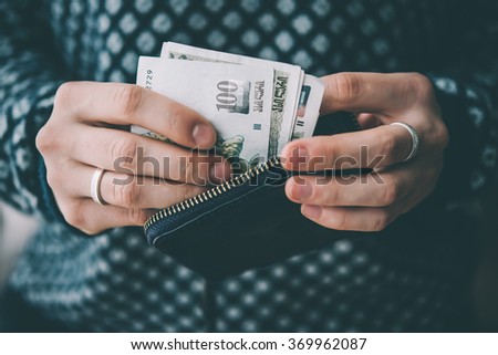 Hands holding georgian lari bills and small money pouch. Toned picture