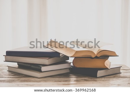 Pile of books on wooden table. Education and reading concept. Toned picture