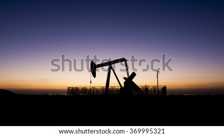 Silhouette of Oil pump at sunset in Bahrain oil field.