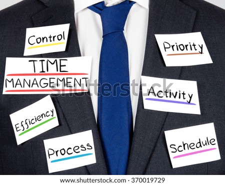 Photo of business suit and tie with TIME MANAGEMENT conceptual words written on paper cards