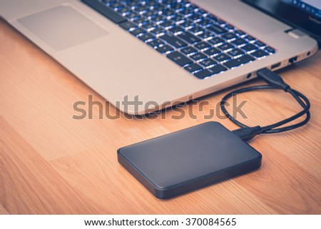 transfer or backup data between laptop and external hard disk on office desktop still life Royalty-Free Stock Photo #370084565