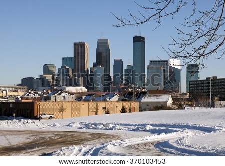 Minneapolis skyline in winter with snow in the foreground. Sunny winter day with urban skyline.