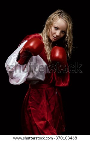 Young pretty woman in red and white silk bathrobe and red gloves with wet hairs isolated on the black background