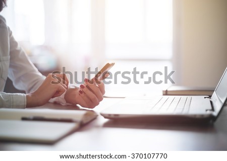 Modern workplace woman using mobile phone in office. Royalty-Free Stock Photo #370107770