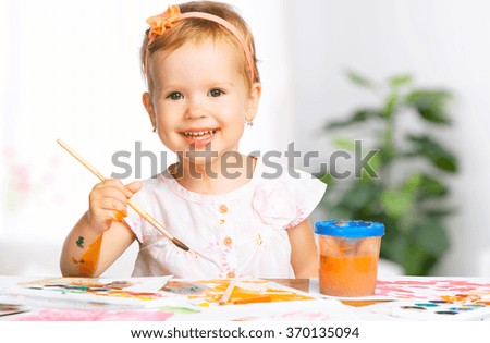 happy baby child girl draws paints