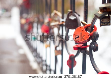 Many love padlocks, heart shaped, close up on a blurred background in winter time