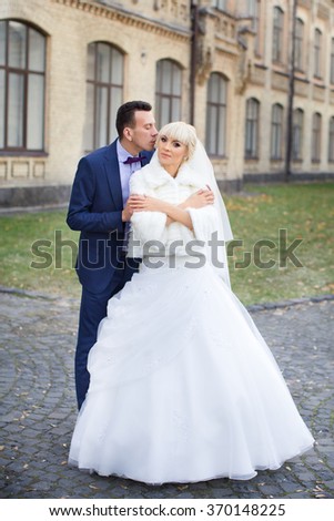 Bride and groom embrace on a walk in the countryside for a walk