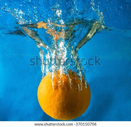 orange in water on a blue background