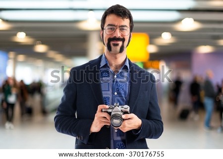 Vintage young man with camera on unfocused background