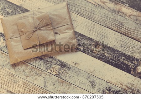 Gift presents design of two wrapped presents stacked on one another on rustic wooden background with free space in matte film finish feel