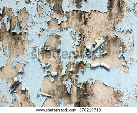 Color paint is peeling on a concrete wall surface