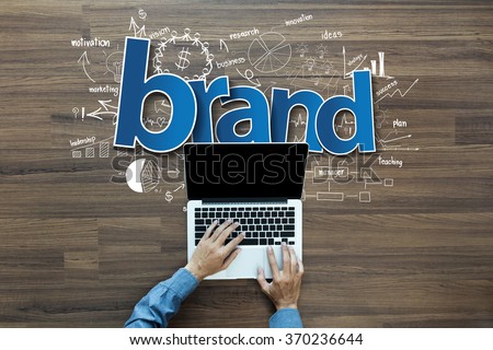 Brand identity ideas concept, Creative thinking drawing charts and graphs strategy plan on wooden table background, Inspiration concept with businessman working on laptop computer PC, Top View