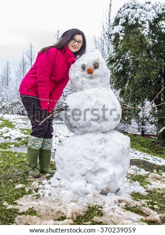 Tourist take photo with snowman.