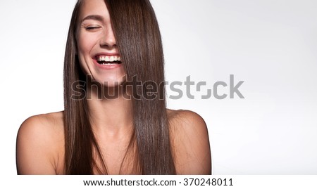 Laughing girl with shiny black hair and perfect clean skin on a white background Royalty-Free Stock Photo #370248011