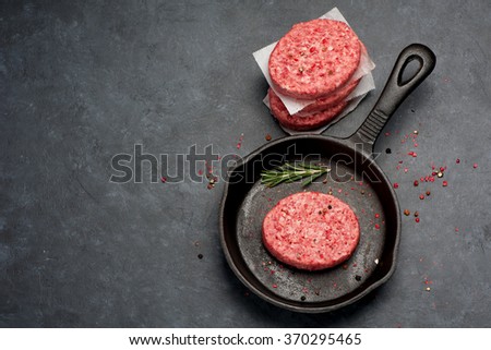 Raw Ground Beef Meat Burger cutlets  in cast iron pan. Top view