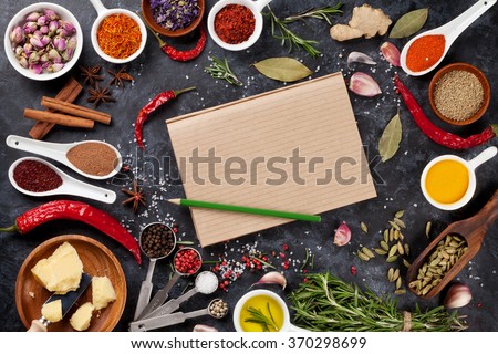 Notepad for your recipe with herbs and spices over black stone background. Top view with copy space Royalty-Free Stock Photo #370298699