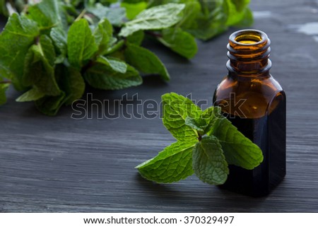 Essential aroma oil with peppermint  on wooden background. 