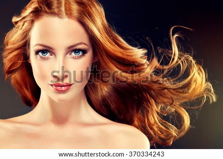 Beautiful model with long curly red hair .  Styling hairstyles curls .Wavy shiny 