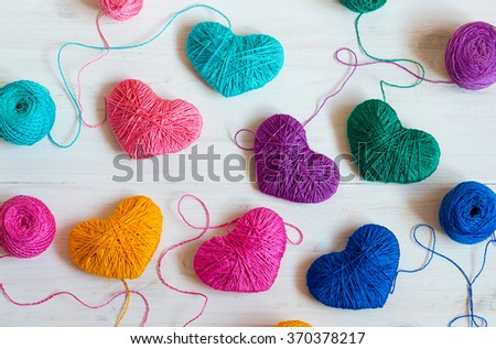 Multicolored Hearts with a balls of thread on white wooden background. Image of Valentines day