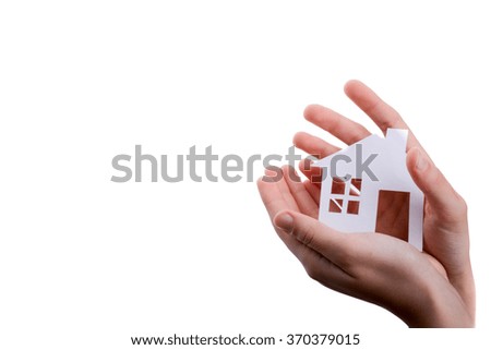 Hand holding an isolated paper house with a white background