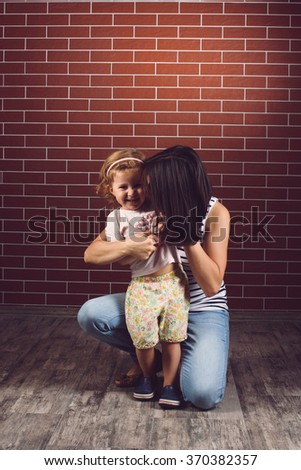 mother hugging laughing girl at studio