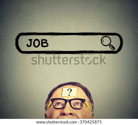 Senior man in glasses looking up searching for a job isolated on gray wall background. Employment job market concept 