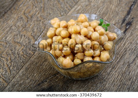 Canned chickpeas in the bowl on wood background