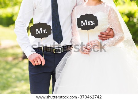 Funny bride and groom with Mr and Mrs signs. Happy wedding day Royalty-Free Stock Photo #370462742