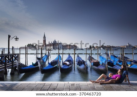 Couple relaxing in venice with blue boats in background