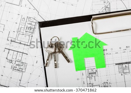 Model house on construction plan for house building, keys and clipboard. Real Estate Concept.