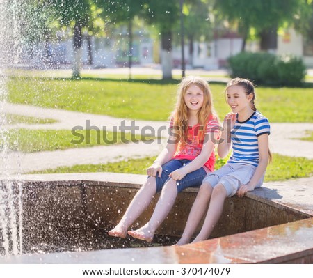 two happy girls at the fountain