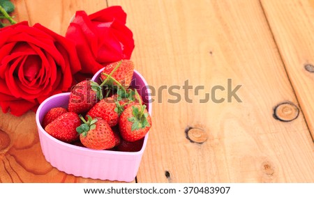Red Strawberry in pink heart shape bowl with red rose