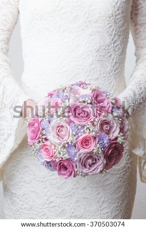 Pink and lilac wedding bouquet of roses, statice and gypsophila