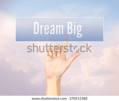 Dream big concept with hand pressing a button on blurred abstract background with pantone color process