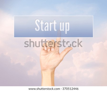 Start up concept with hand pressing a button on blurred abstract background with pantone color process