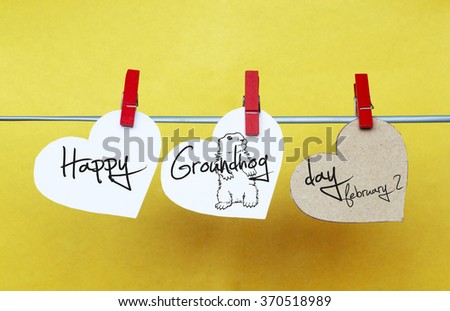 white hearts with clothespins hanging on clothesline on yellow background. text Happy Groundhog Day 2016 February 2. cute  groundhog. toned image